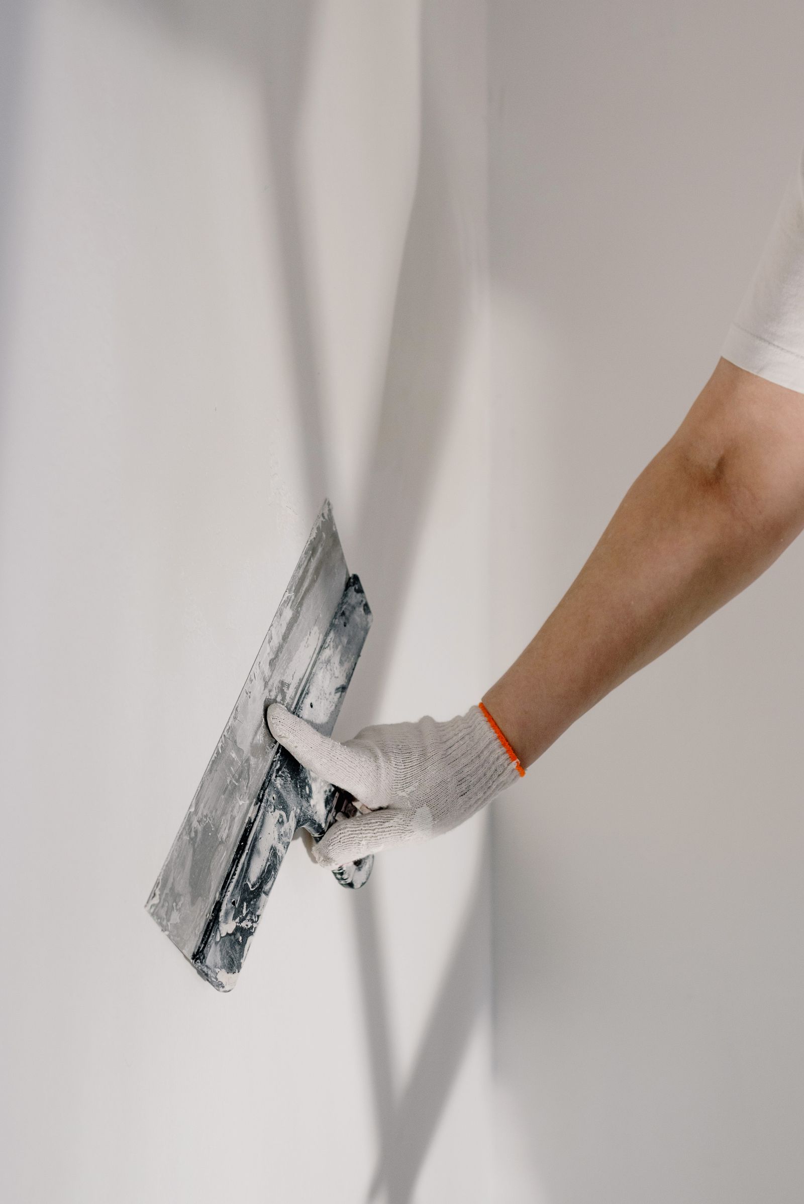 A decorator making good a wall with a filling knife